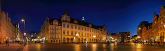 A city street at night with a clock tower in the background