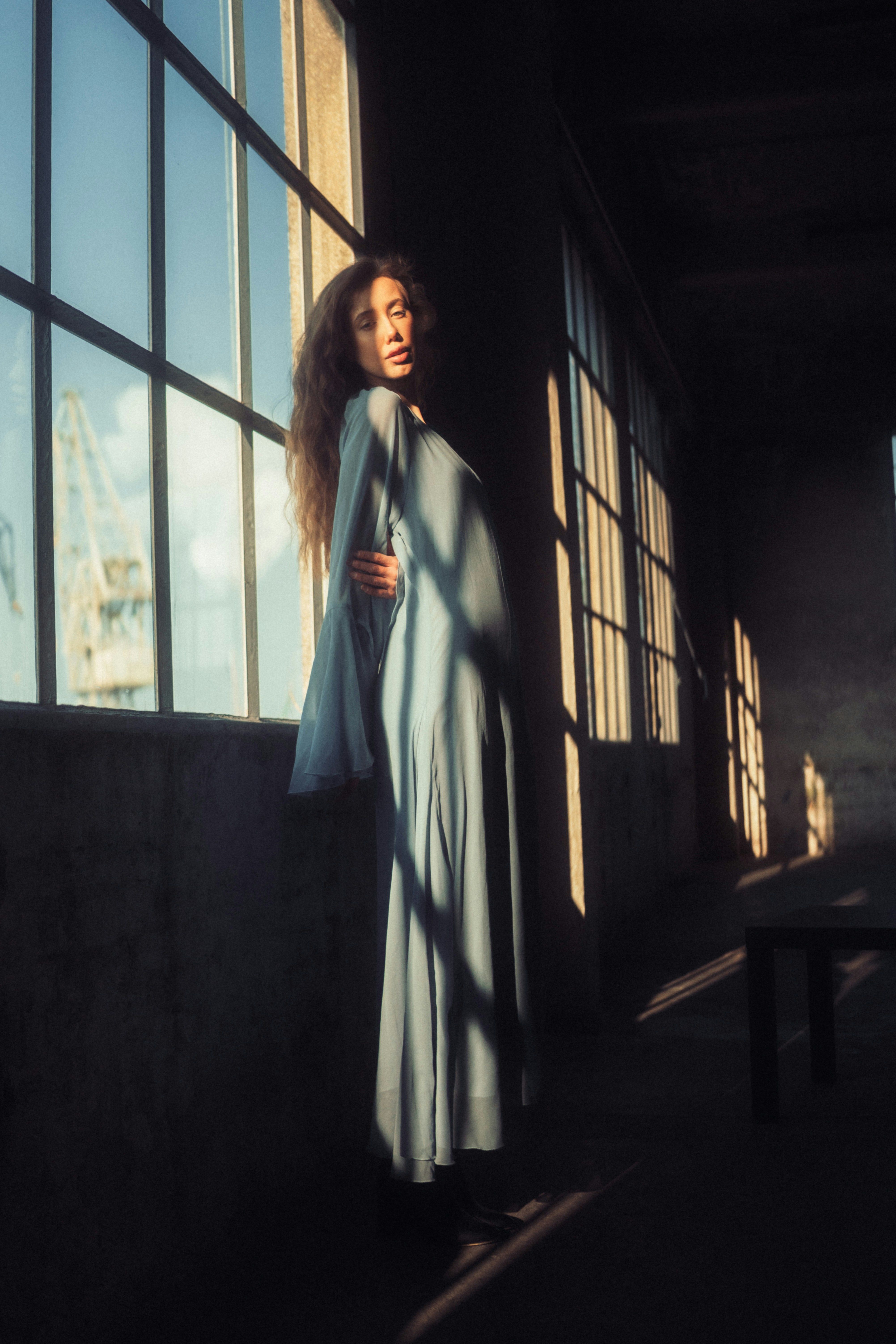 A woman standing in front of a large window