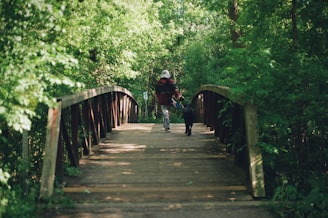 A man riding a bike down a wooden bridge