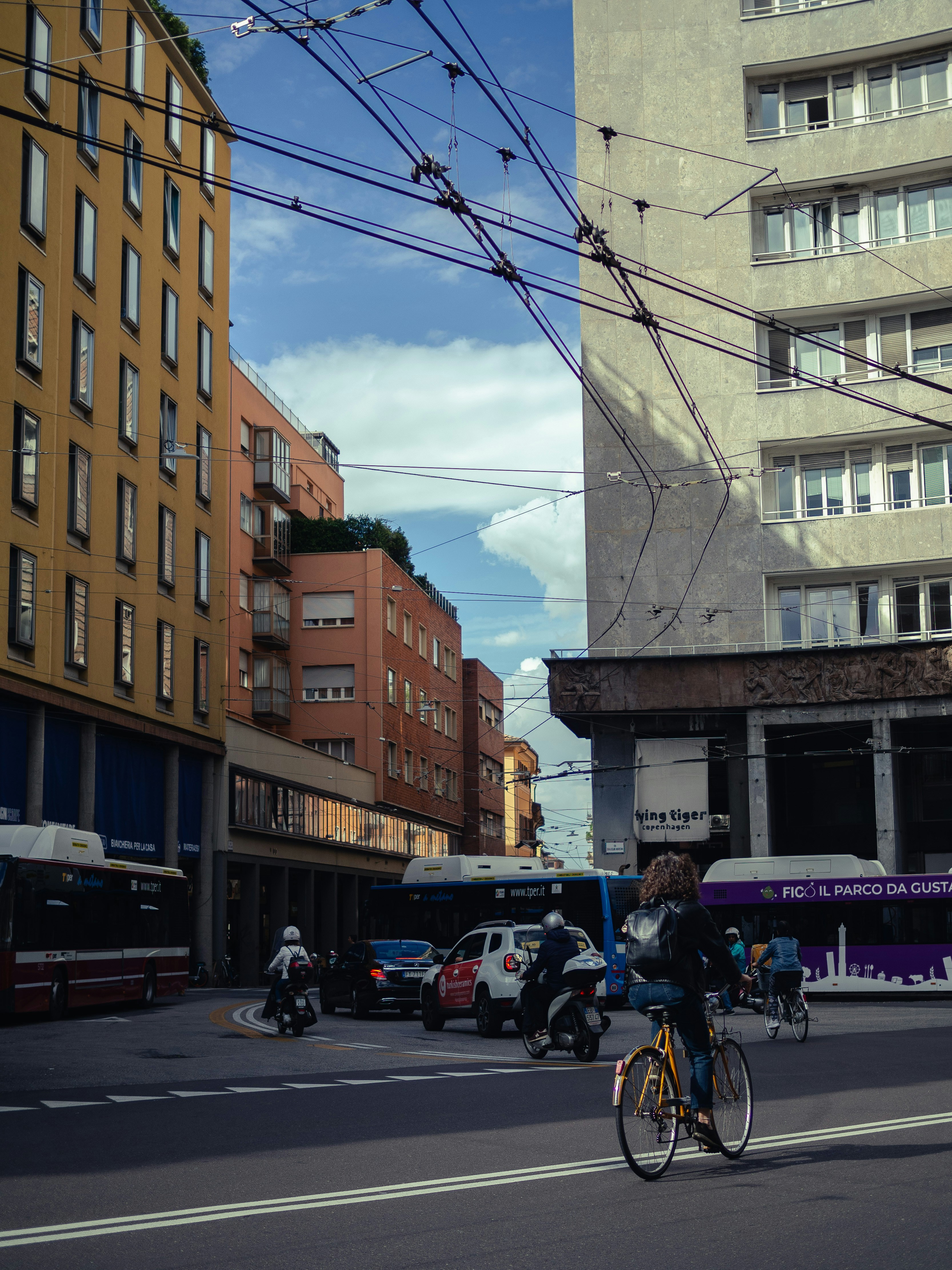 A man riding a bike down a street next to tall buildings