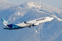 A large passenger jet flying over a mountain range