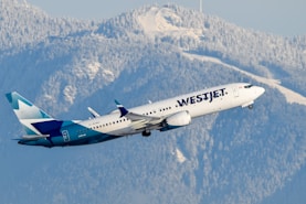 A large passenger jet flying over a mountain range
