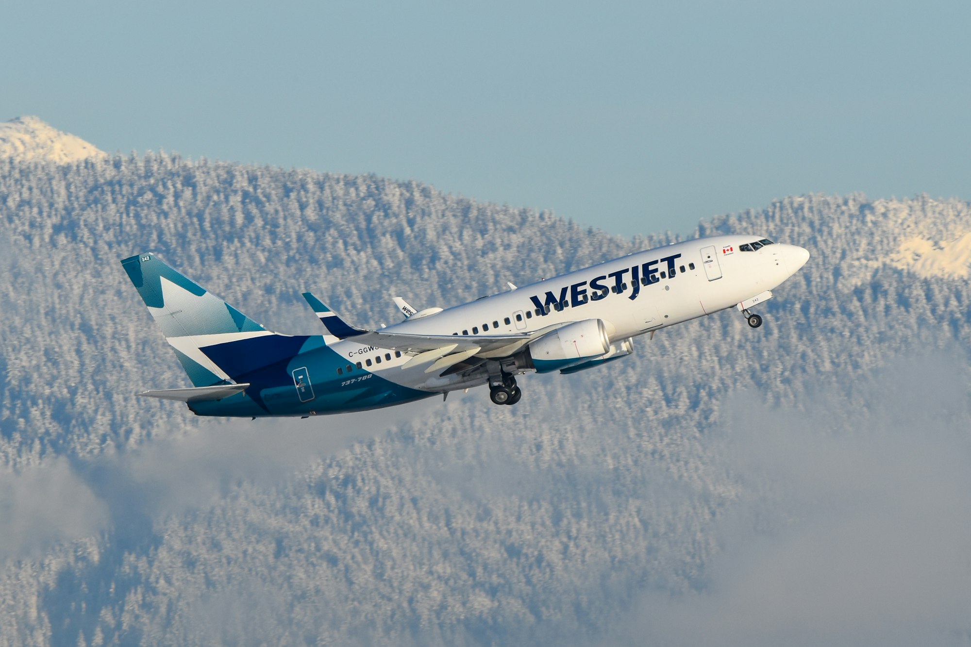 A large passenger jet flying over a mountain range