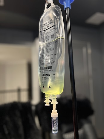 A bottle with a liquid inside of it hanging from a hook