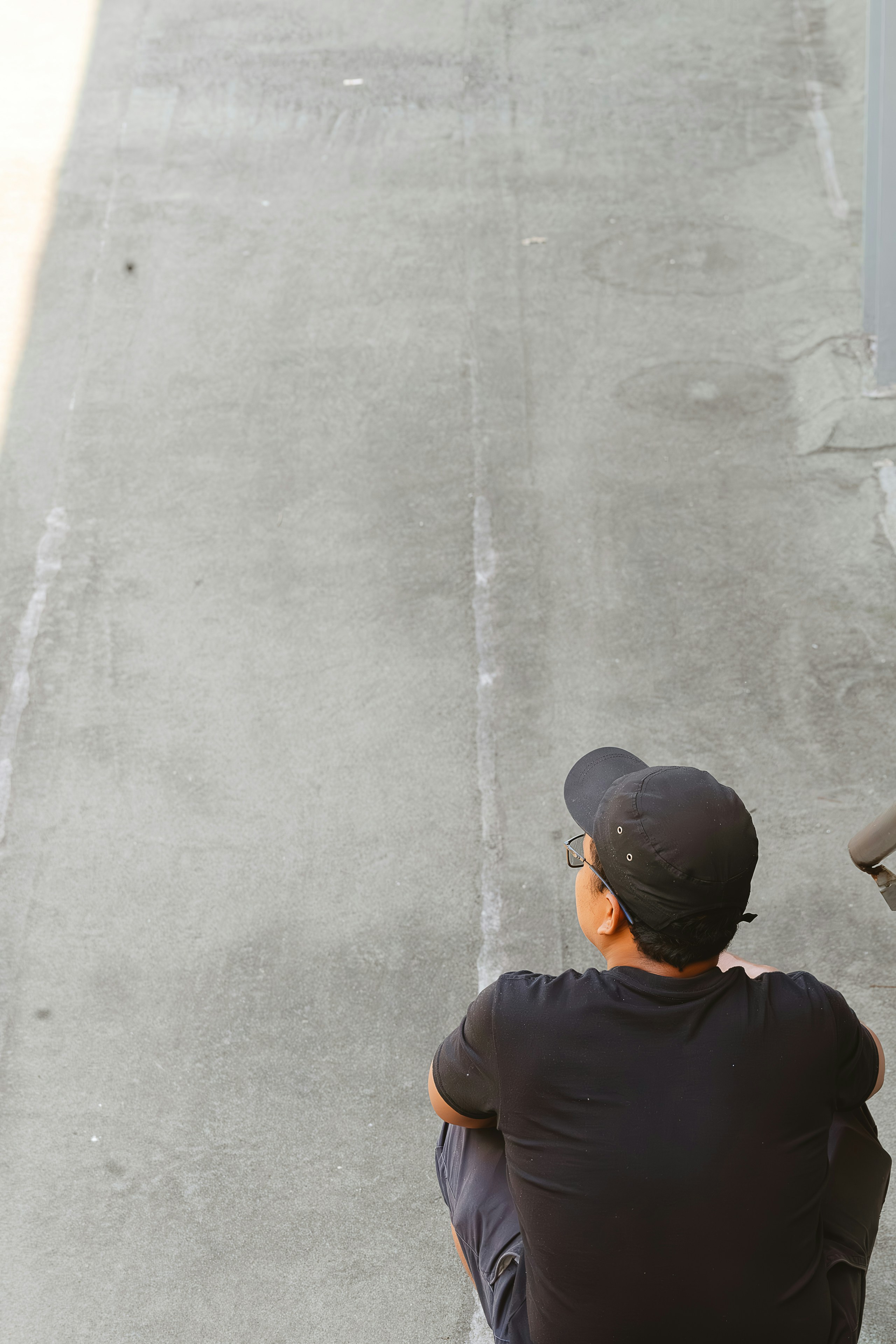 A man sitting on a bench looking down at a street