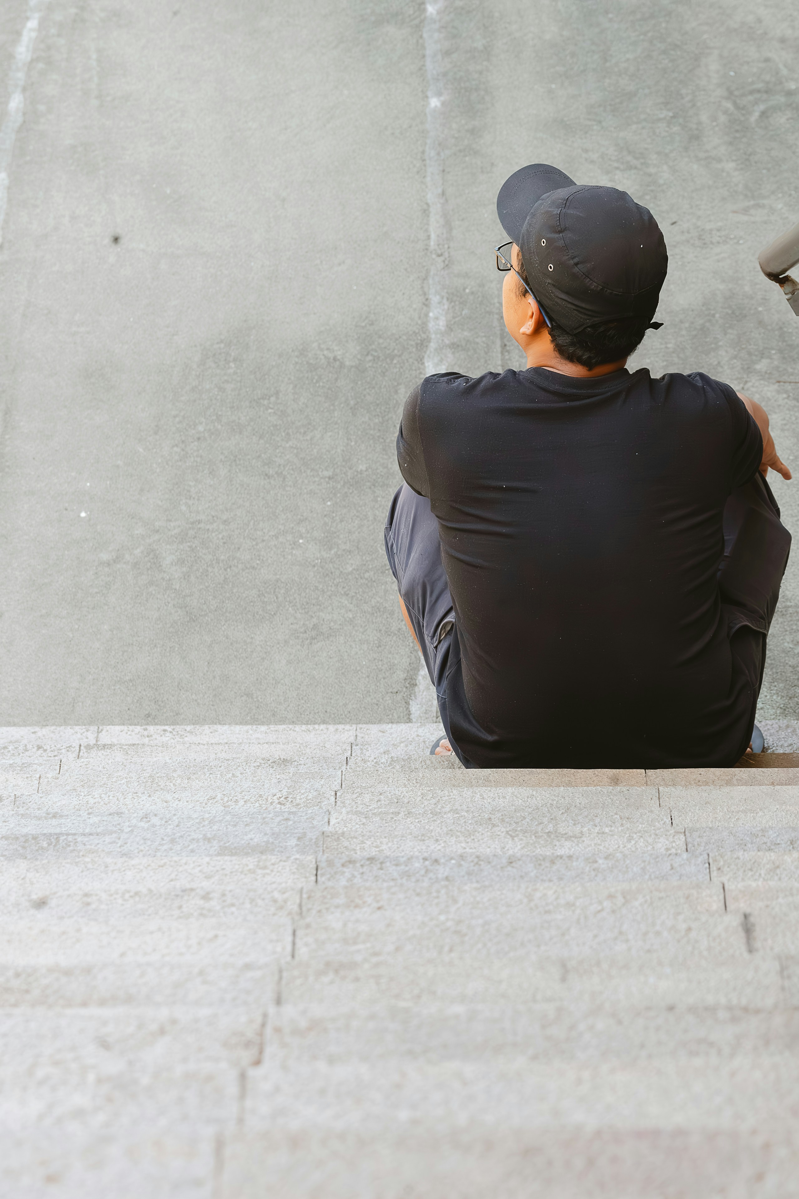 A man sitting on the ground next to a skateboard