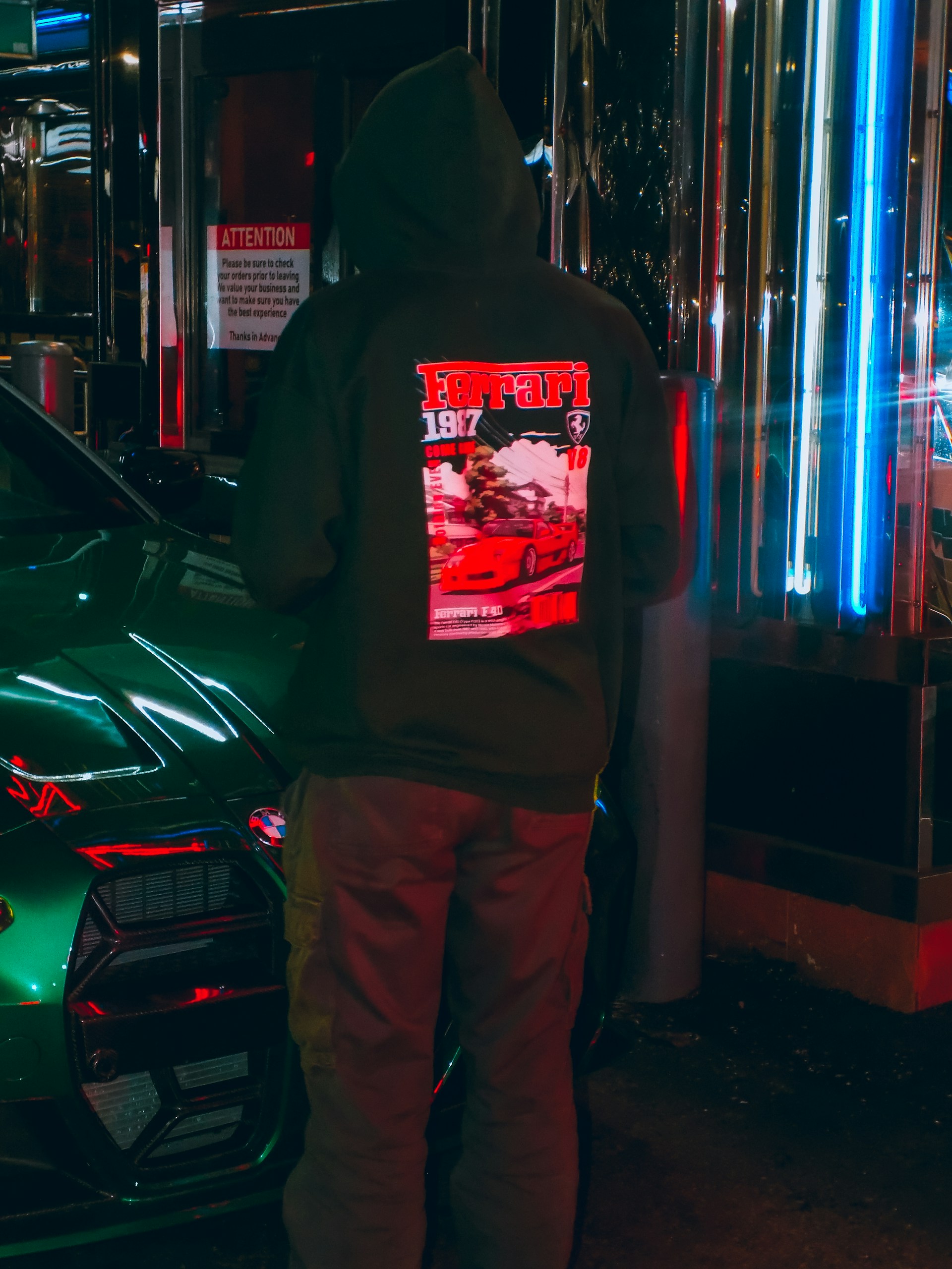 A man standing next to a green car