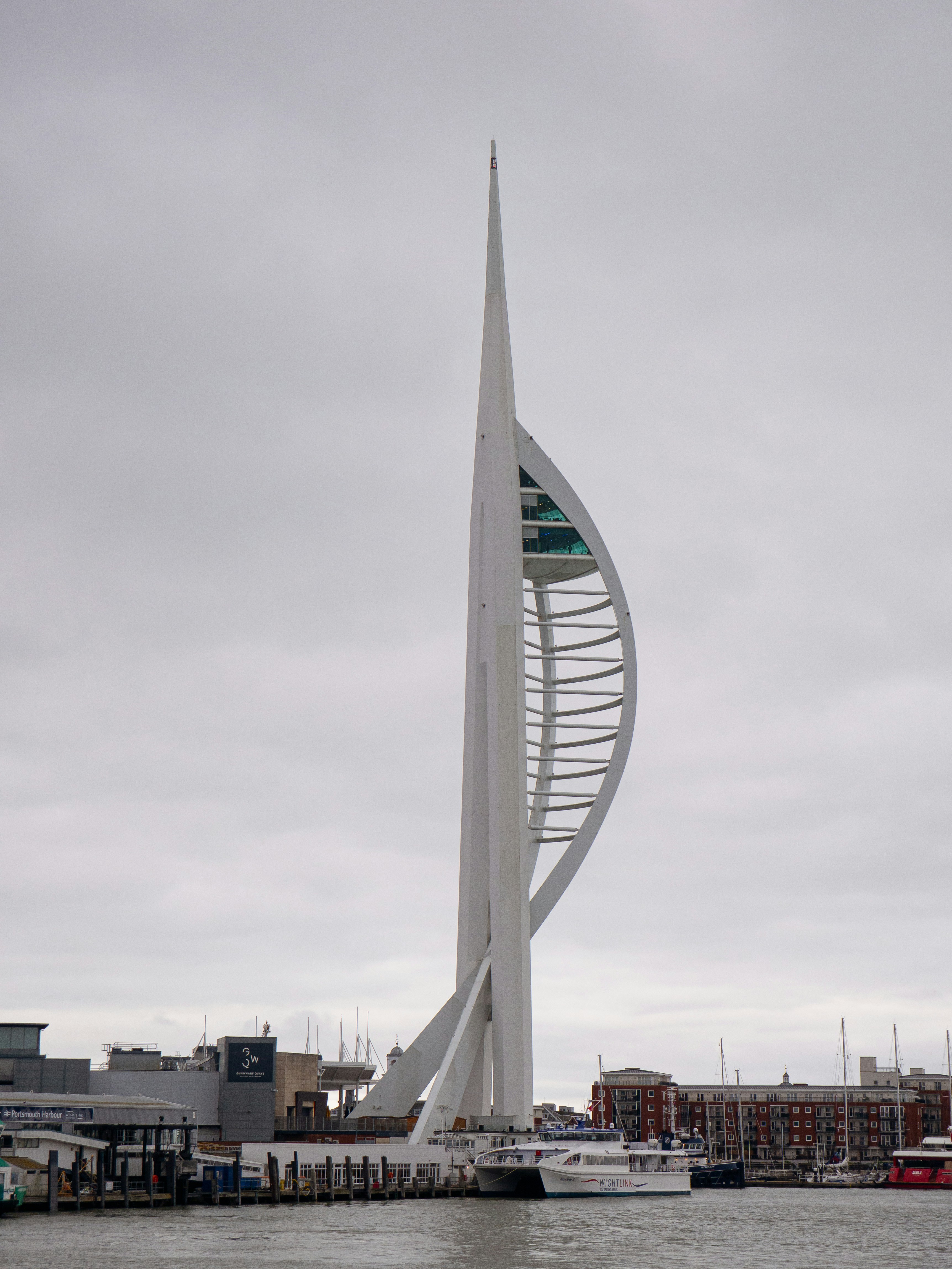 A very tall white tower sitting in the middle of a body of water