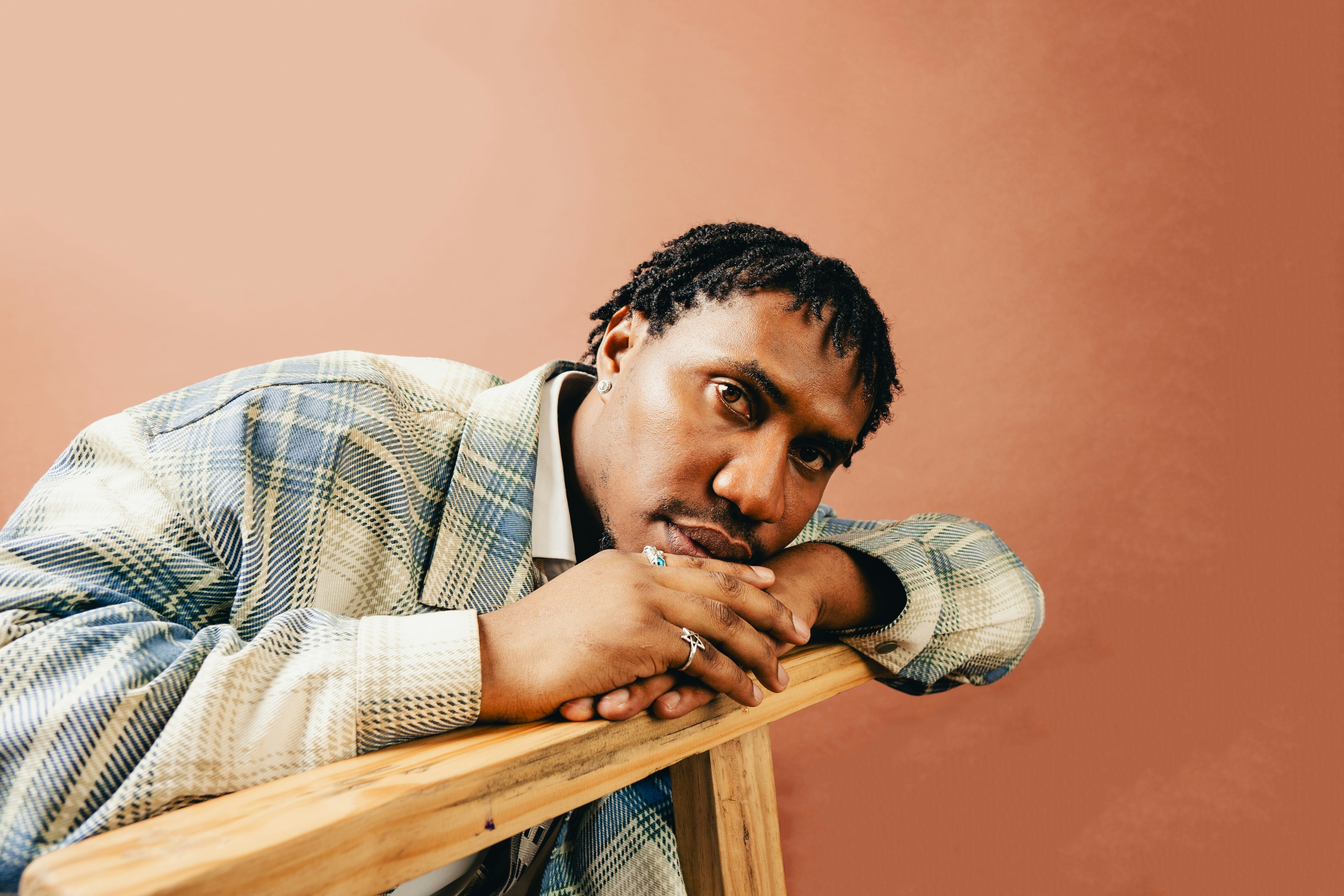 A man leaning up against a wooden chair