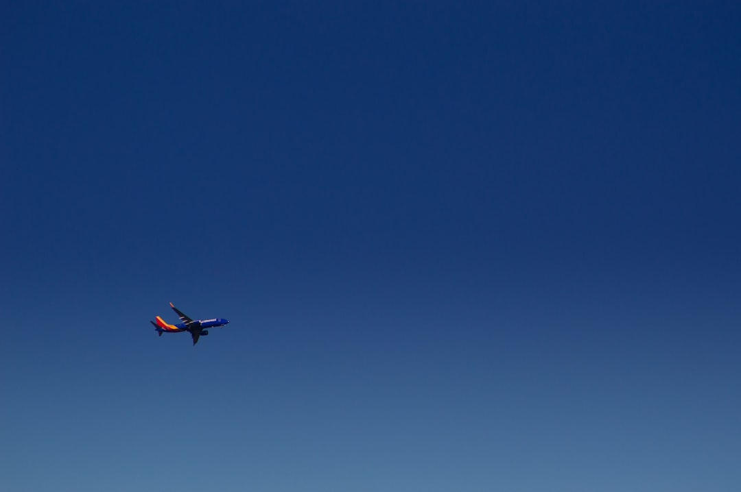 An airplane is flying in the blue sky,