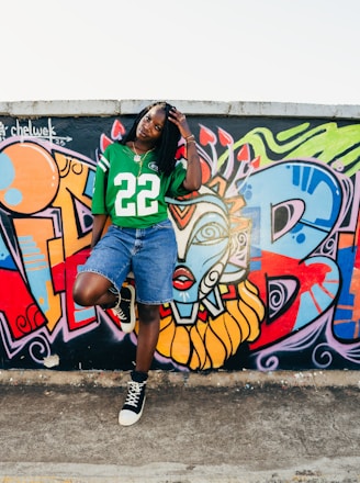 A woman standing in front of a wall covered in graffiti