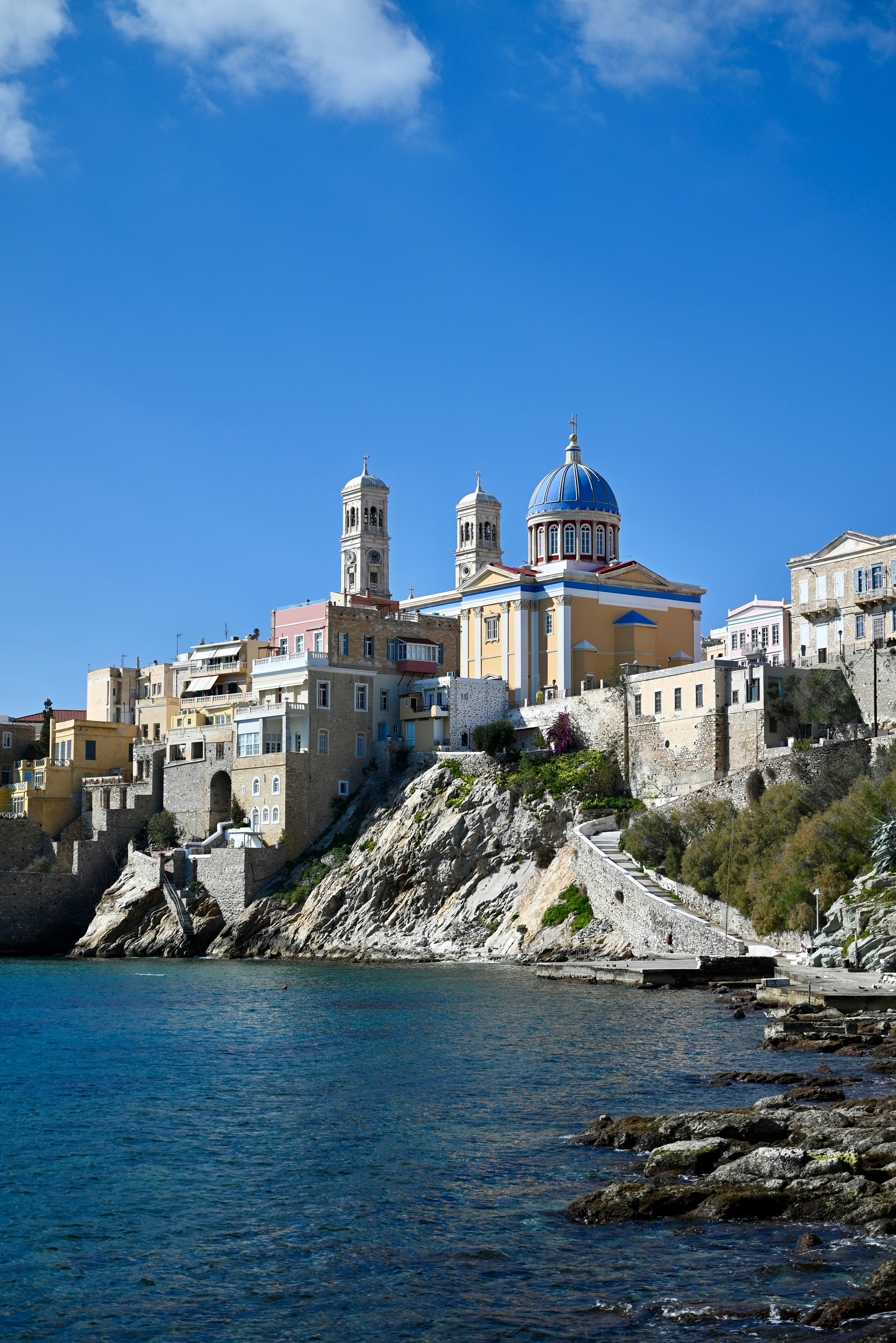 A view of a town on a cliff above the water