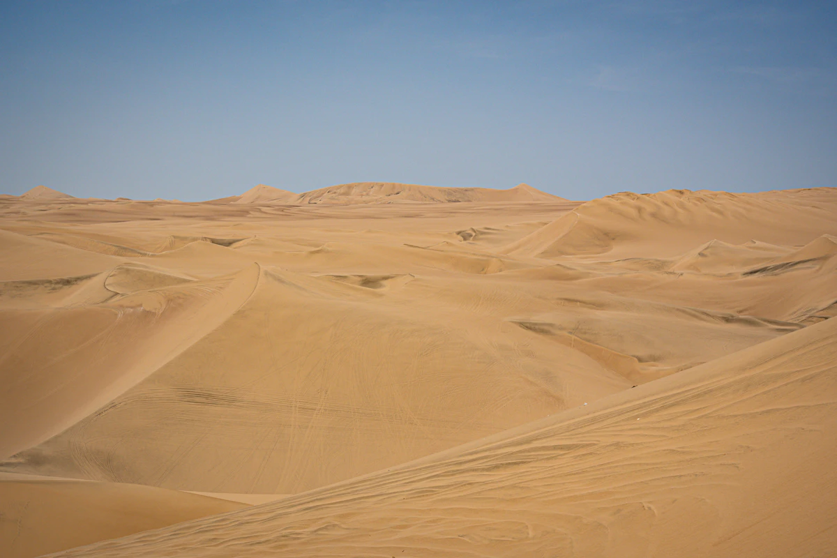 Rolling sand dunes under a pale sky in the desert near Ica