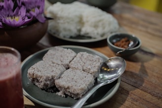 A wooden table topped with plates of food and drinks
