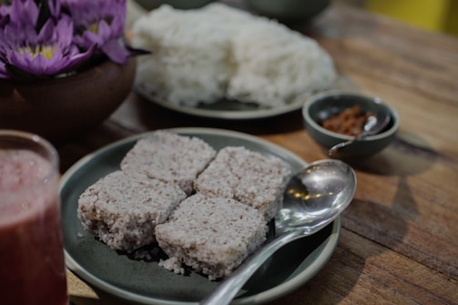 A wooden table topped with plates of food and drinks