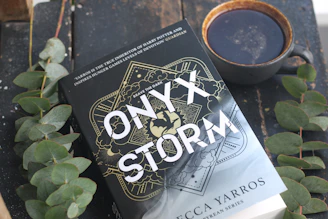 A book sitting on top of a table next to a cup of coffee