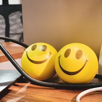 Two yellow balls sitting on top of a table