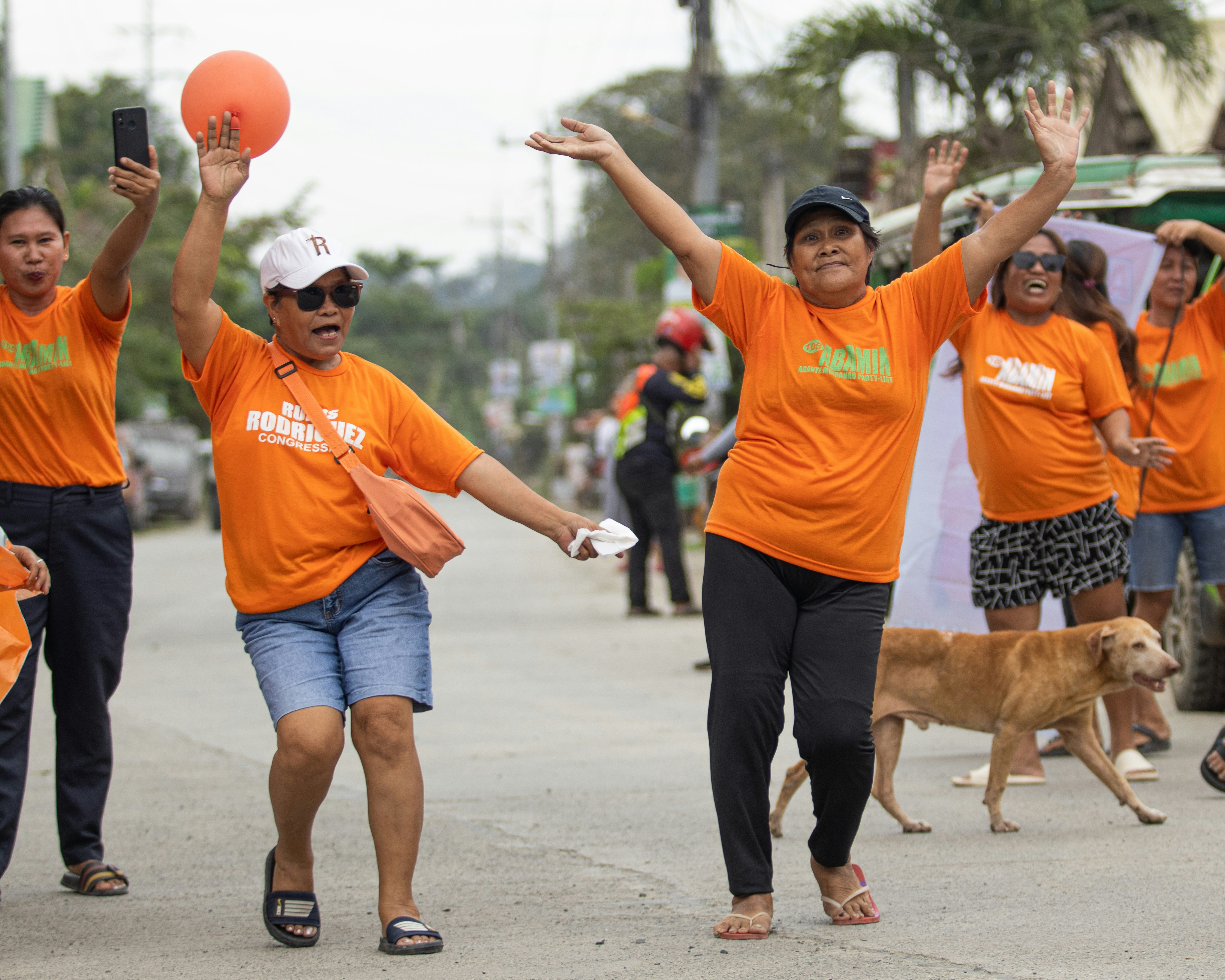 A group of people walking down a street with a dog