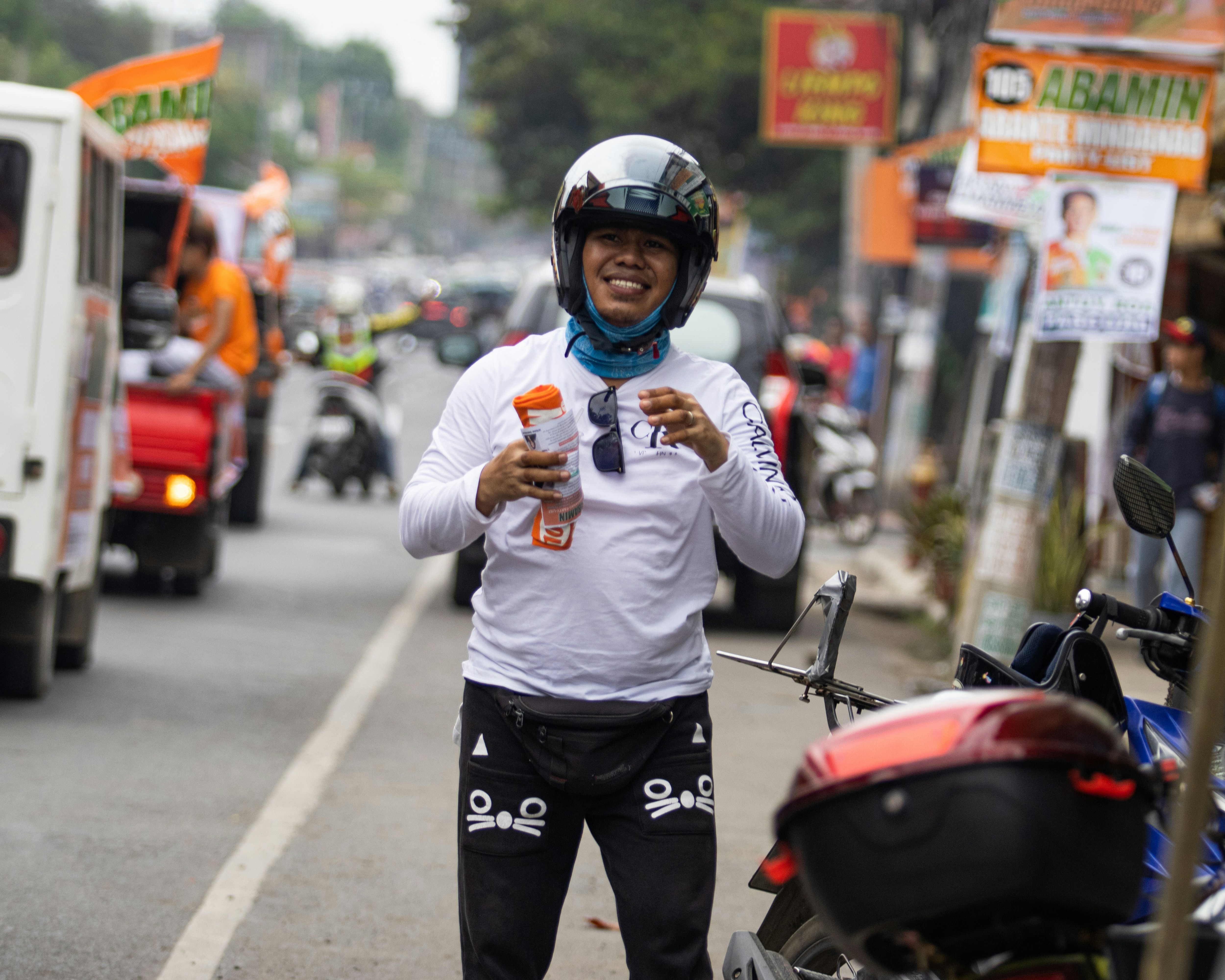 Seorang pria berdiri di pinggir jalan sambil memegang minuman