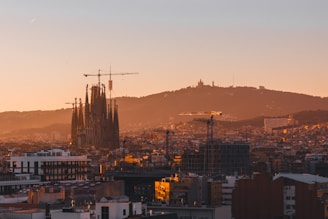 A view of a city at sunset with a mountain in the background