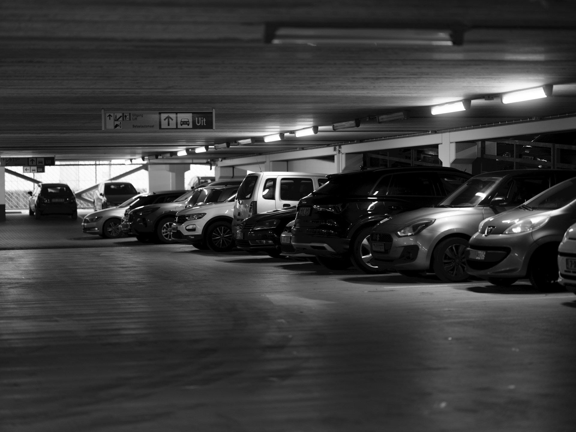 A parking garage filled with lots of parked cars