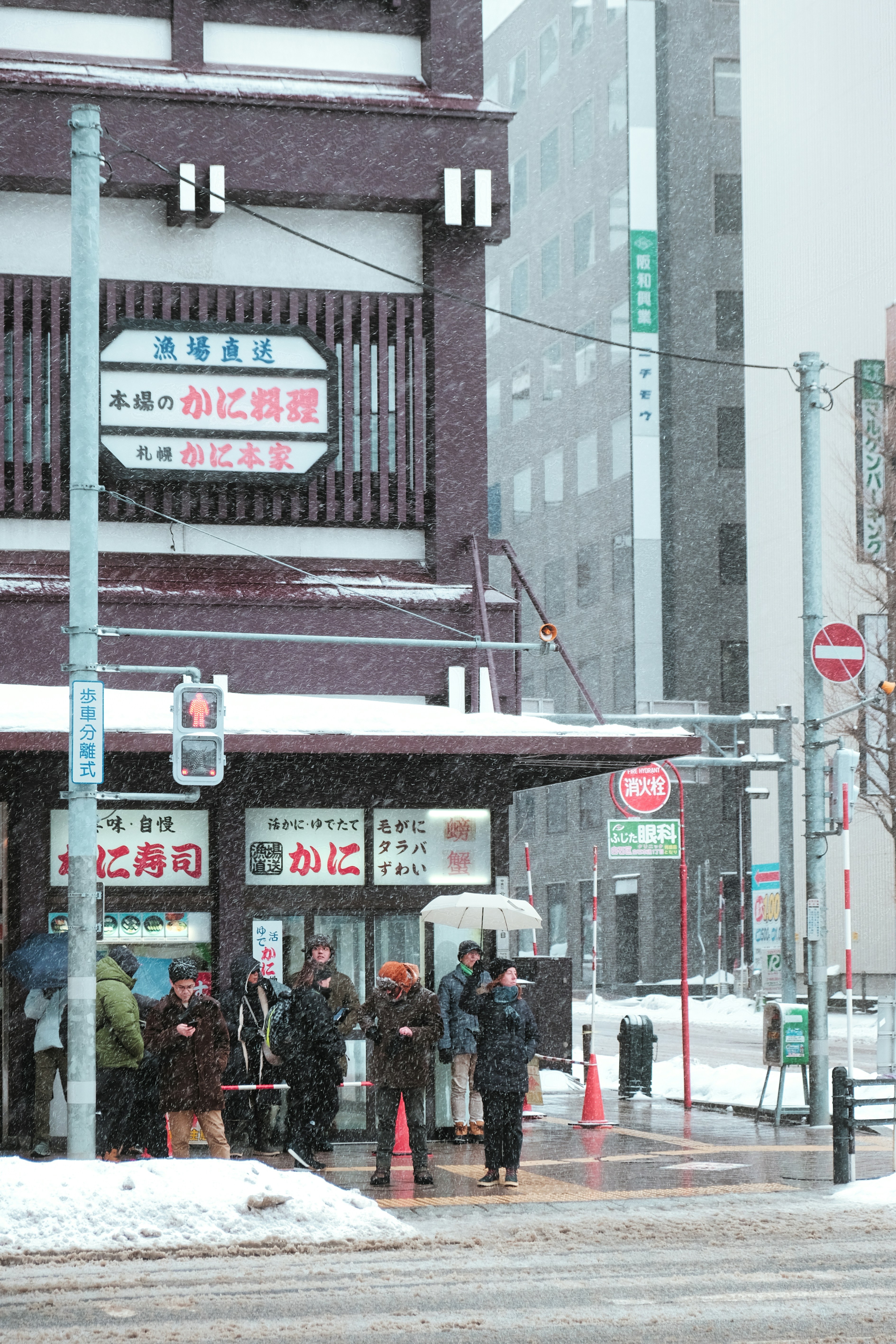 A group of people standing outside of a building in the snow