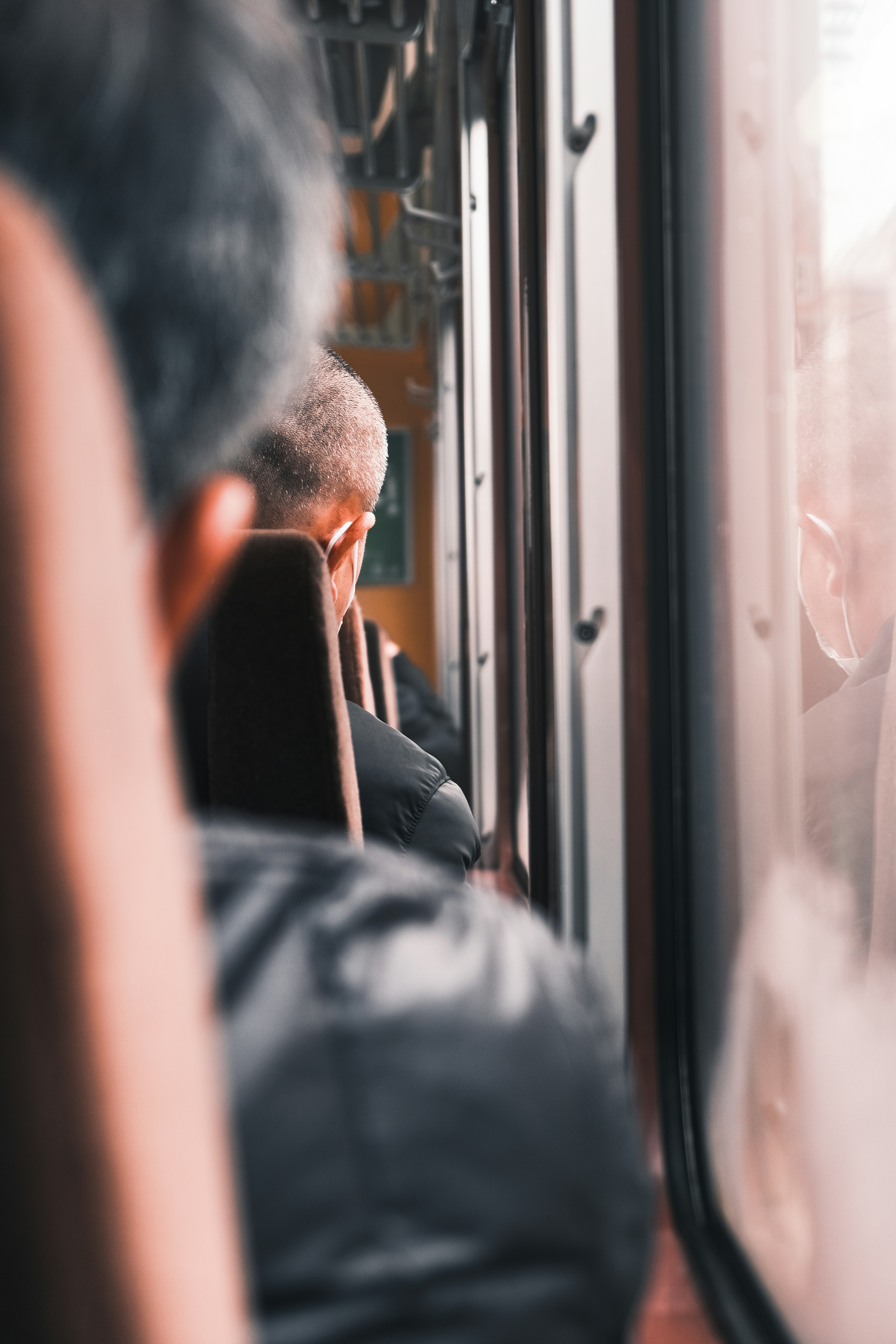 A man sitting on a train looking out the window