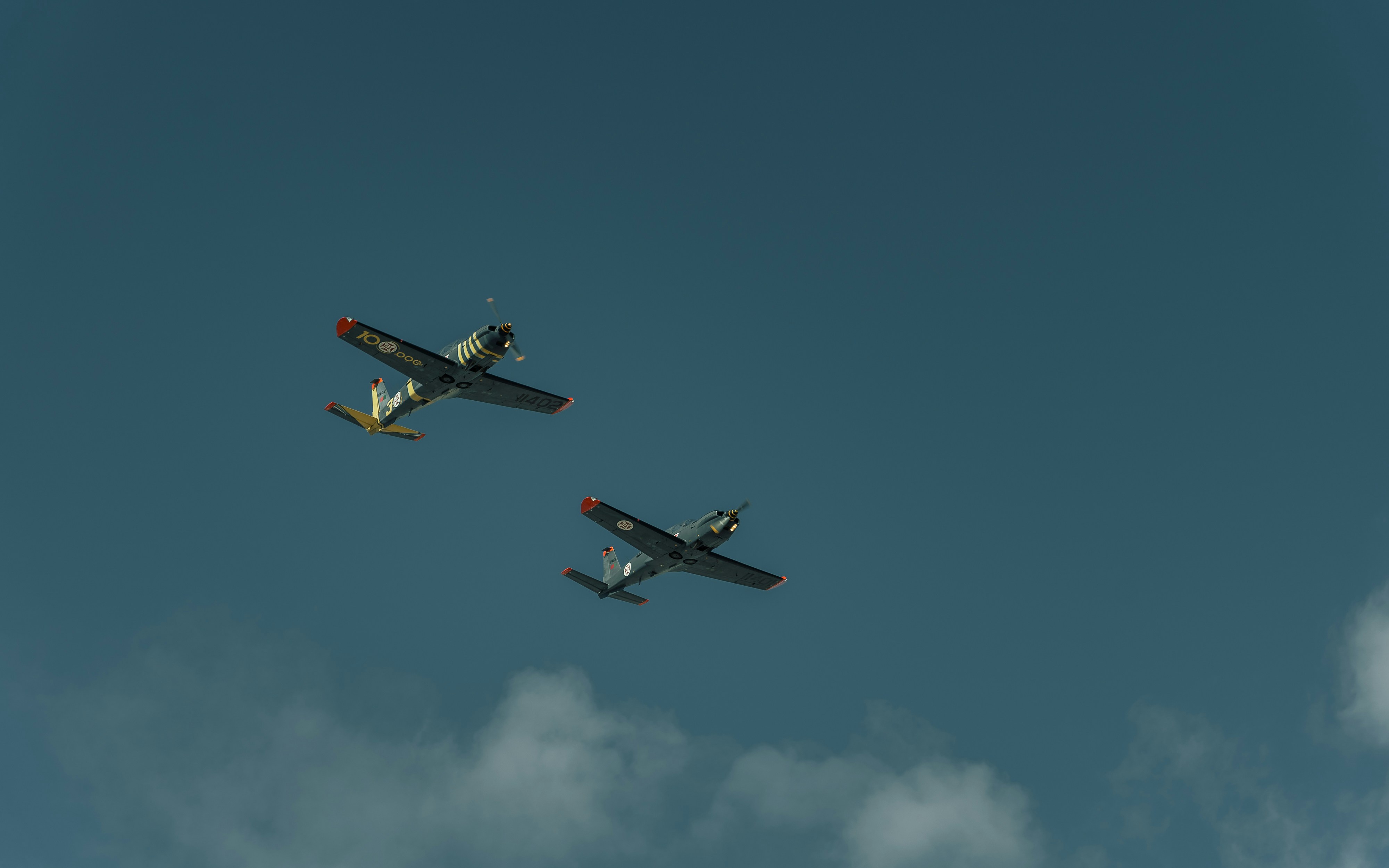 Two airplanes are flying in the sky together