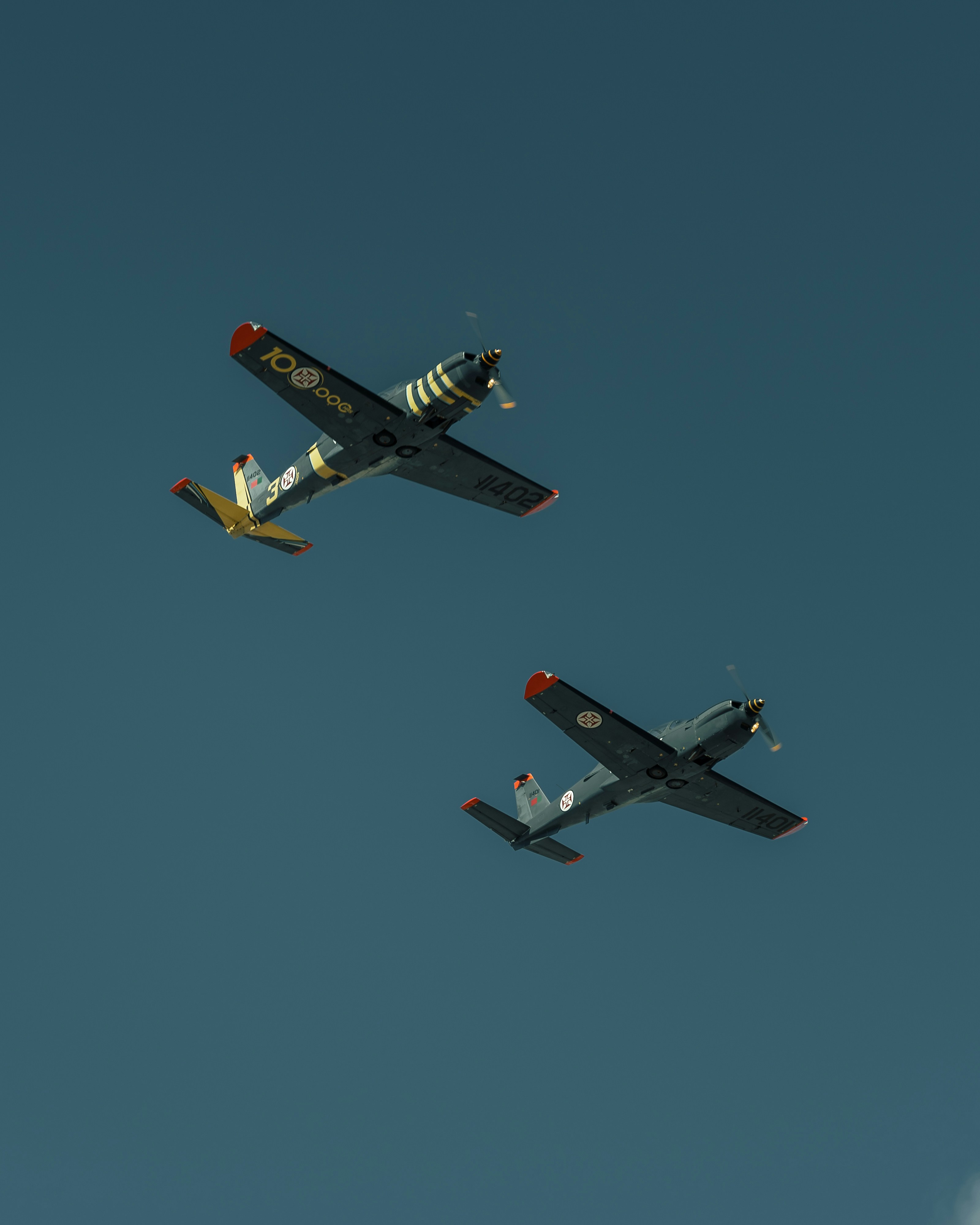Two airplanes flying side by side in the sky
