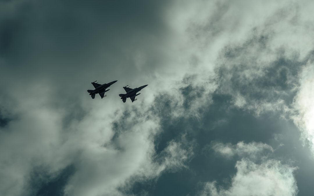 Two airplanes flying in the sky on a cloudy day,