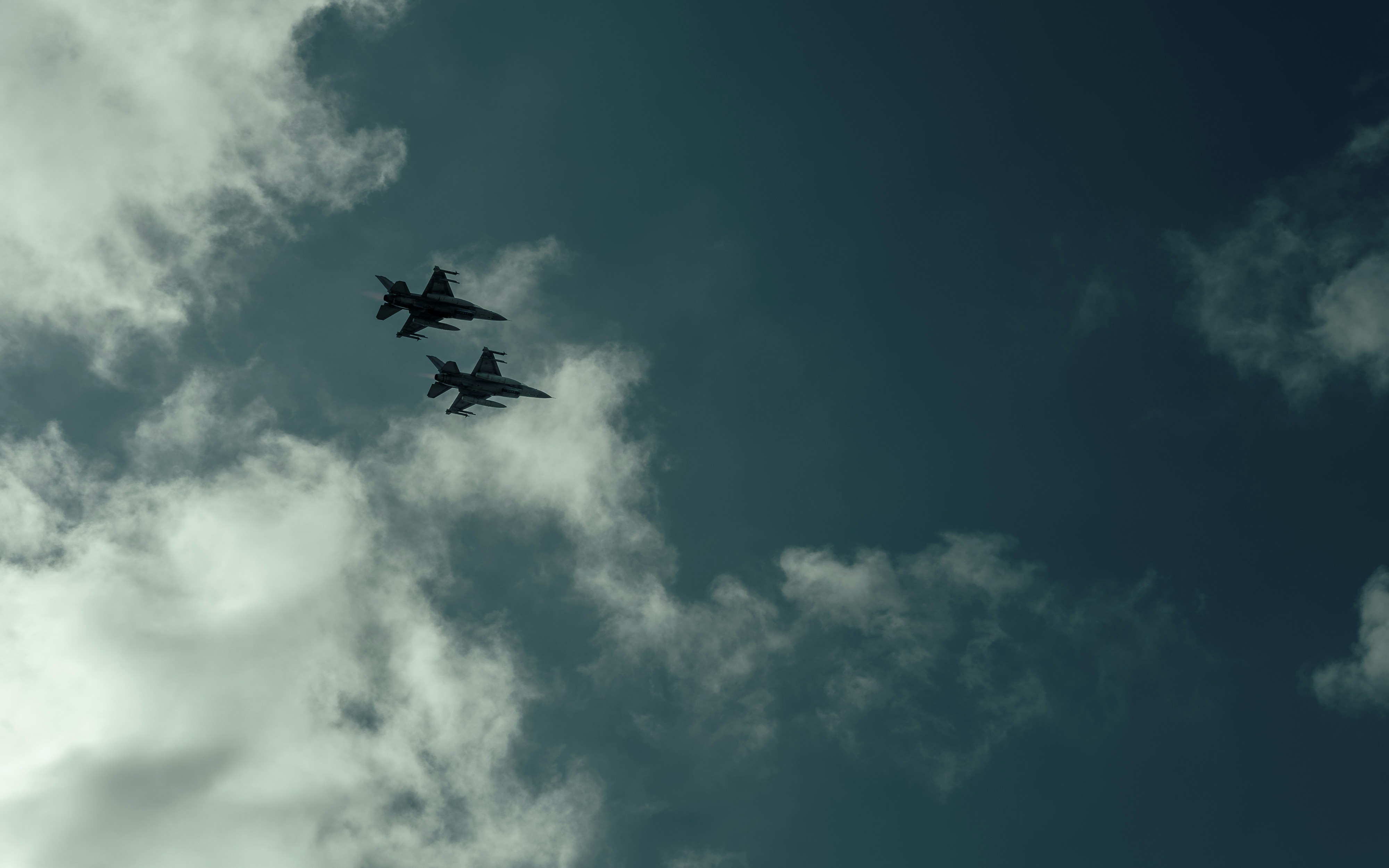 A couple of planes flying through a cloudy sky, 