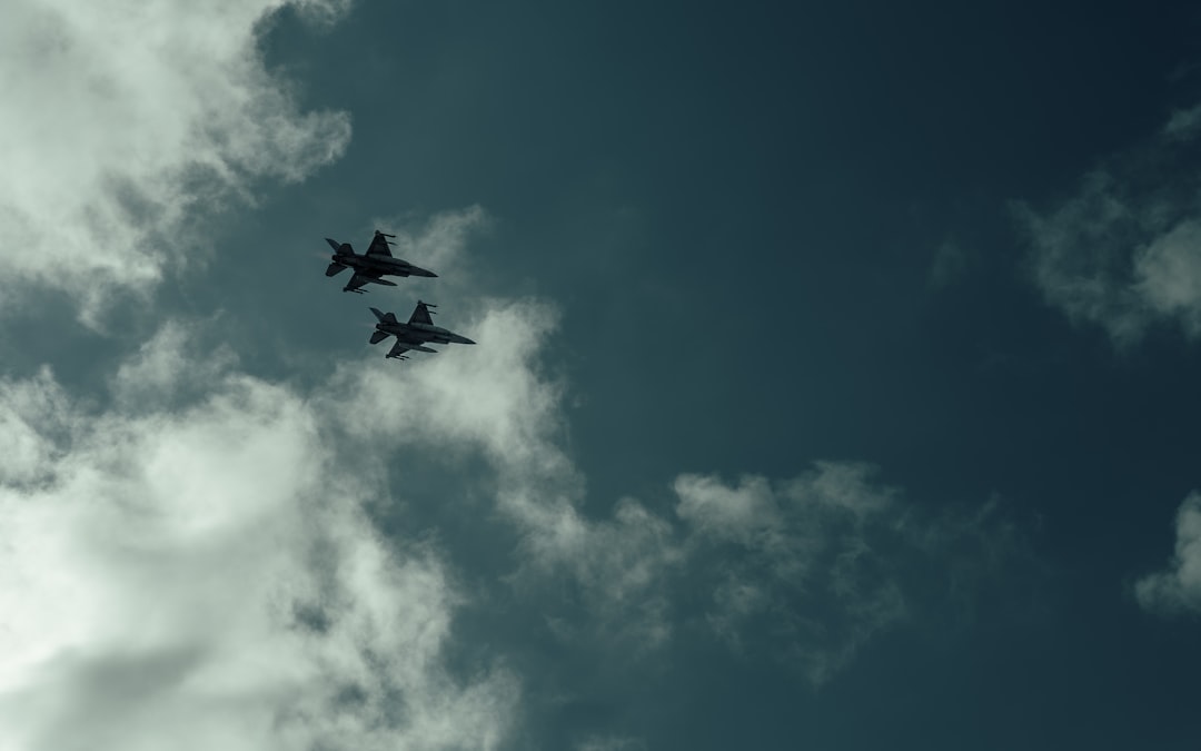 A couple of planes flying through a cloudy sky,