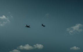 A group of airplanes flying through a cloudy sky