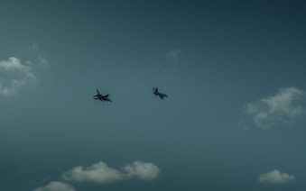 A group of airplanes flying through a cloudy sky