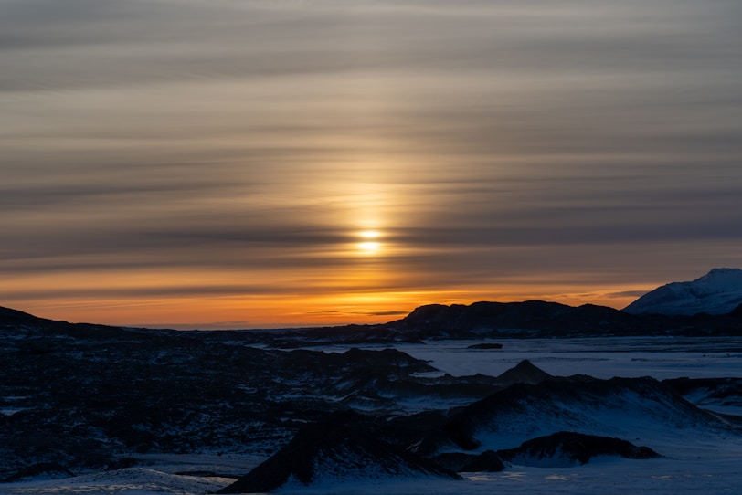 The sun is setting over a mountain range