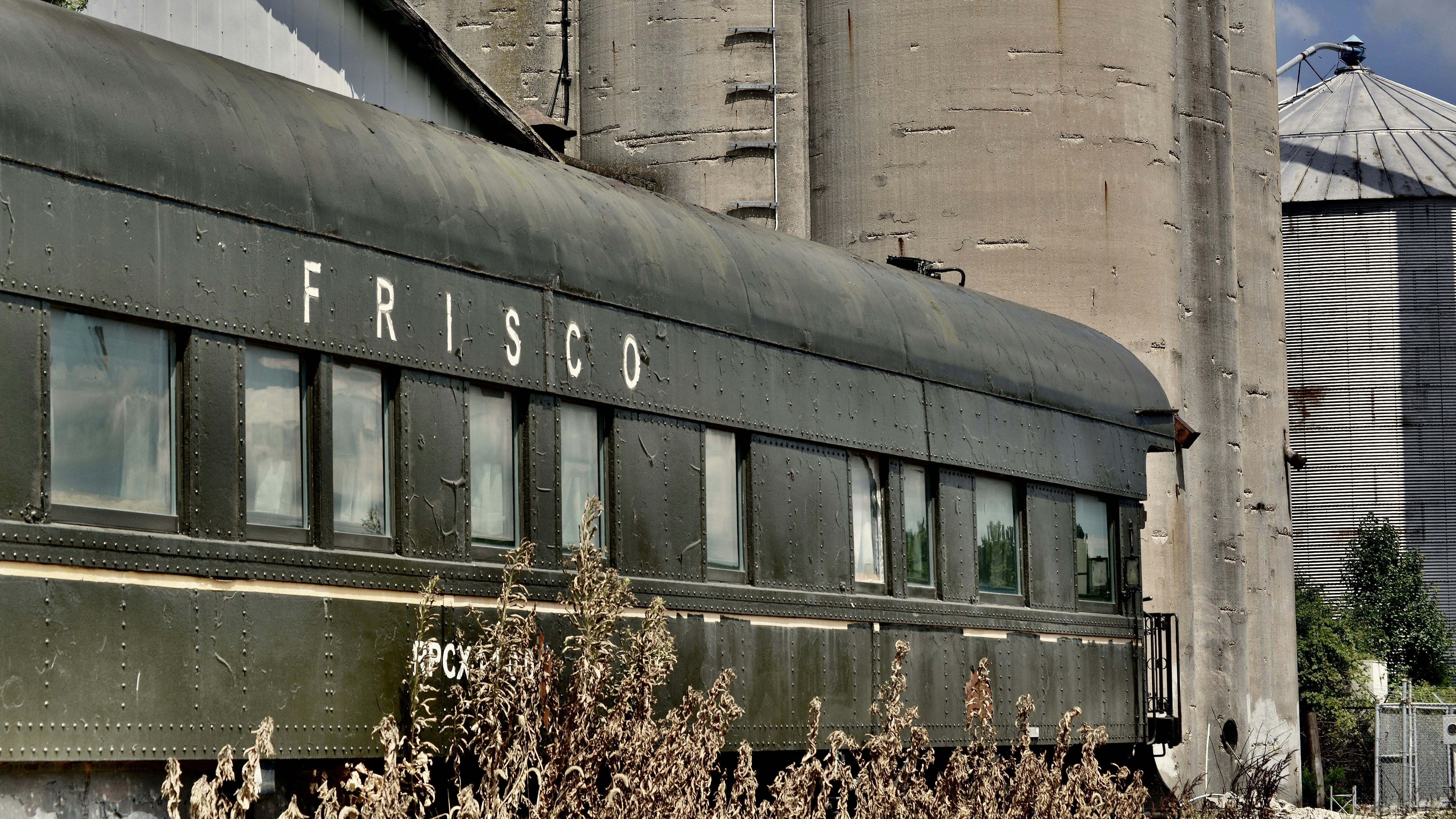 Fotomural An old train is parked in front of a grain silo