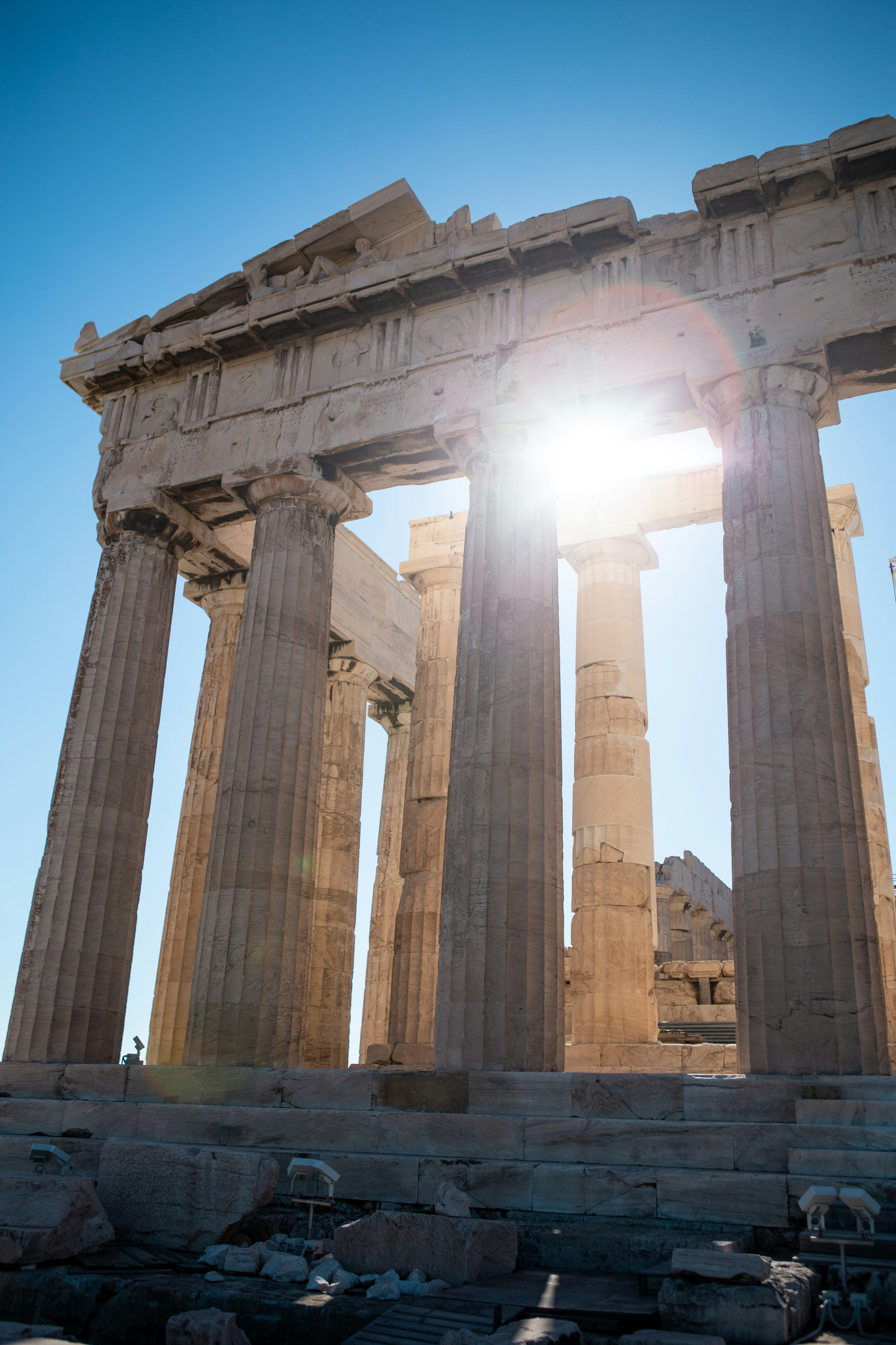 The sun shines brightly through the columns of the temple