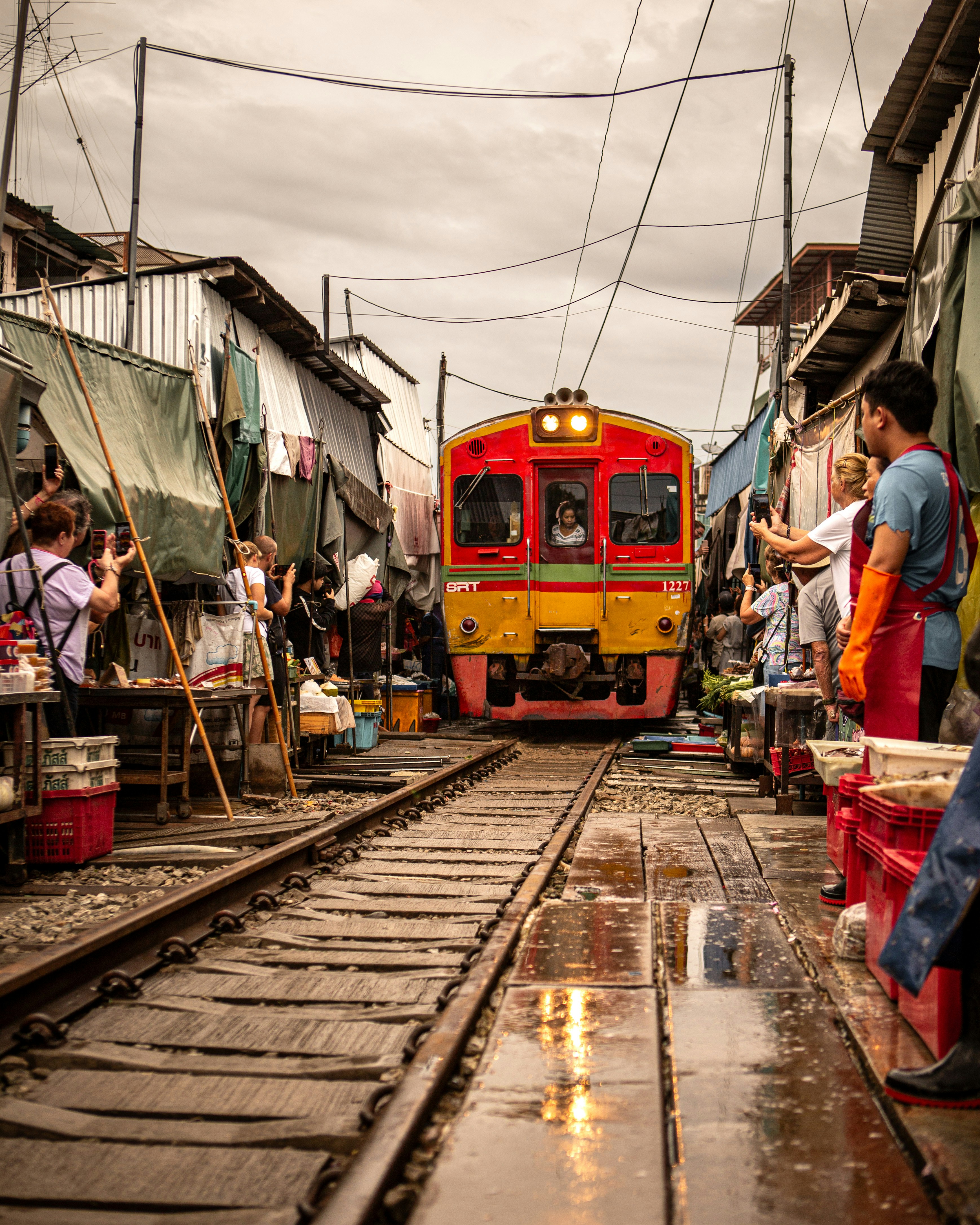 A red and yellow train traveling down train tracks
