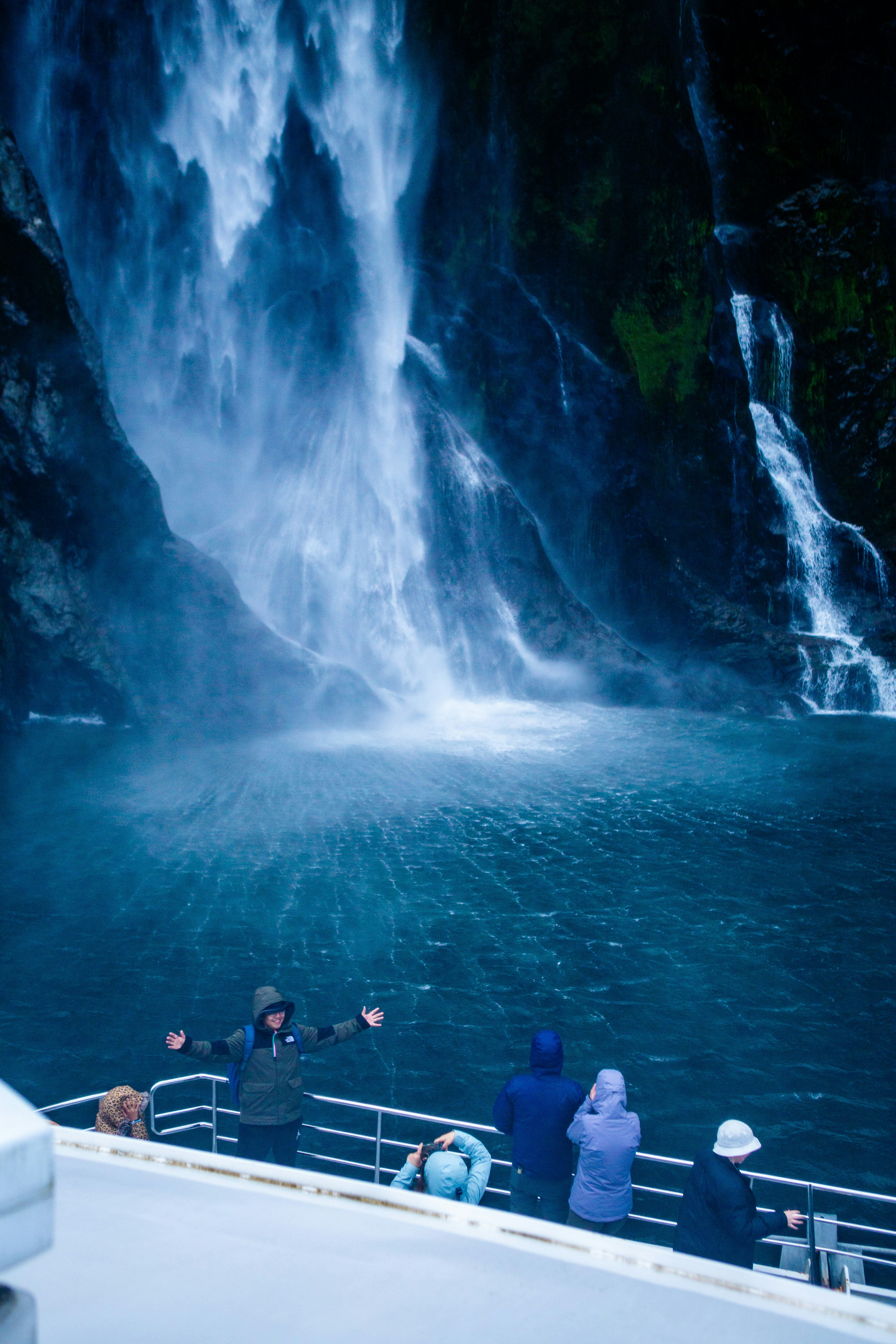 A group of people on a boat watching a waterfall