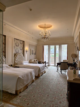 A hotel room with two beds and a chandelier