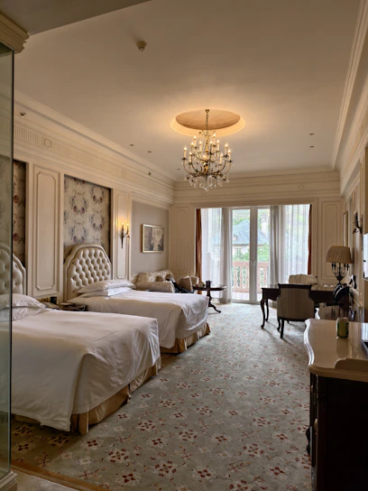 A hotel room with two beds and a chandelier