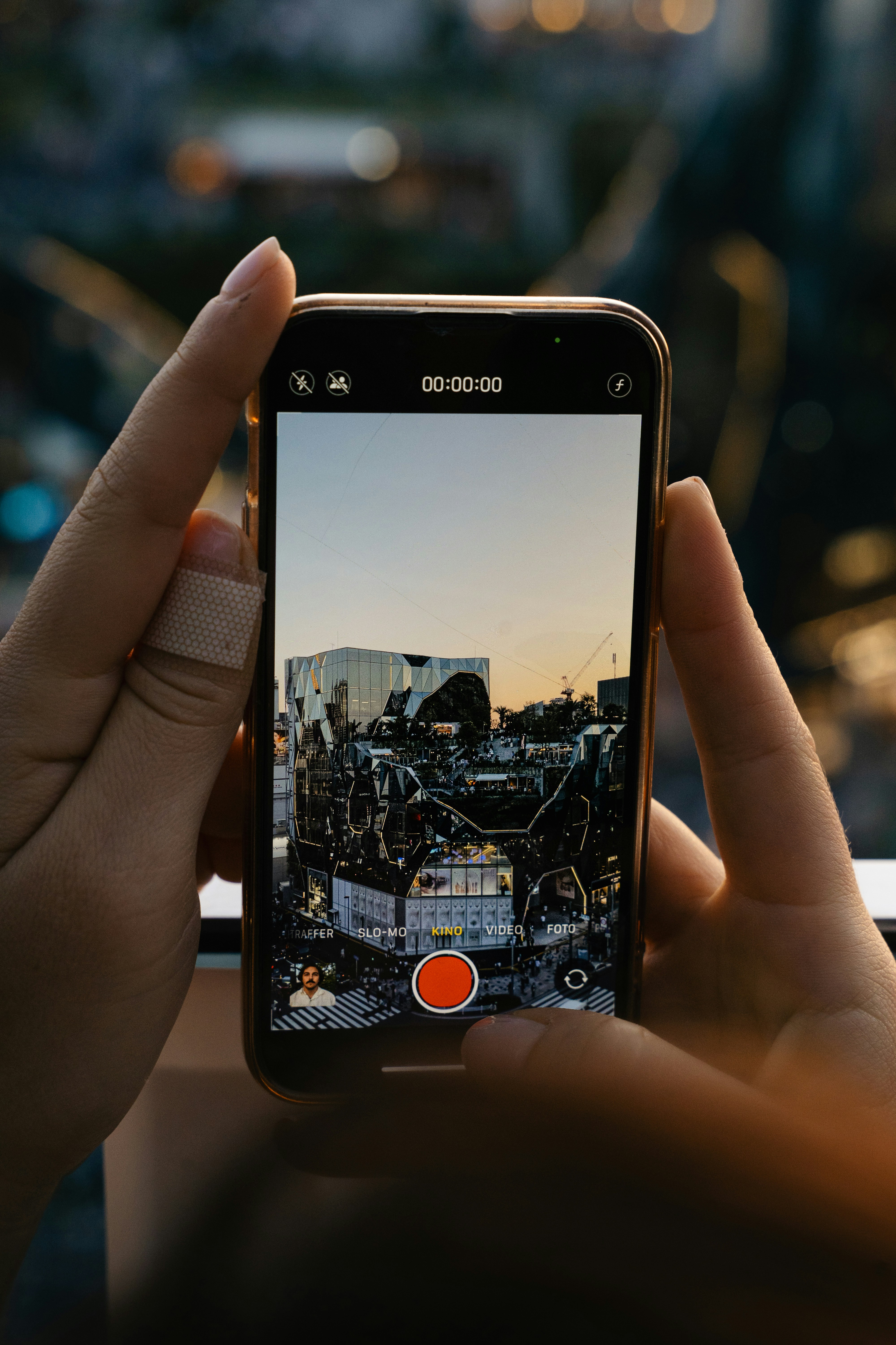 A person holding a cell phone taking a picture of a city
