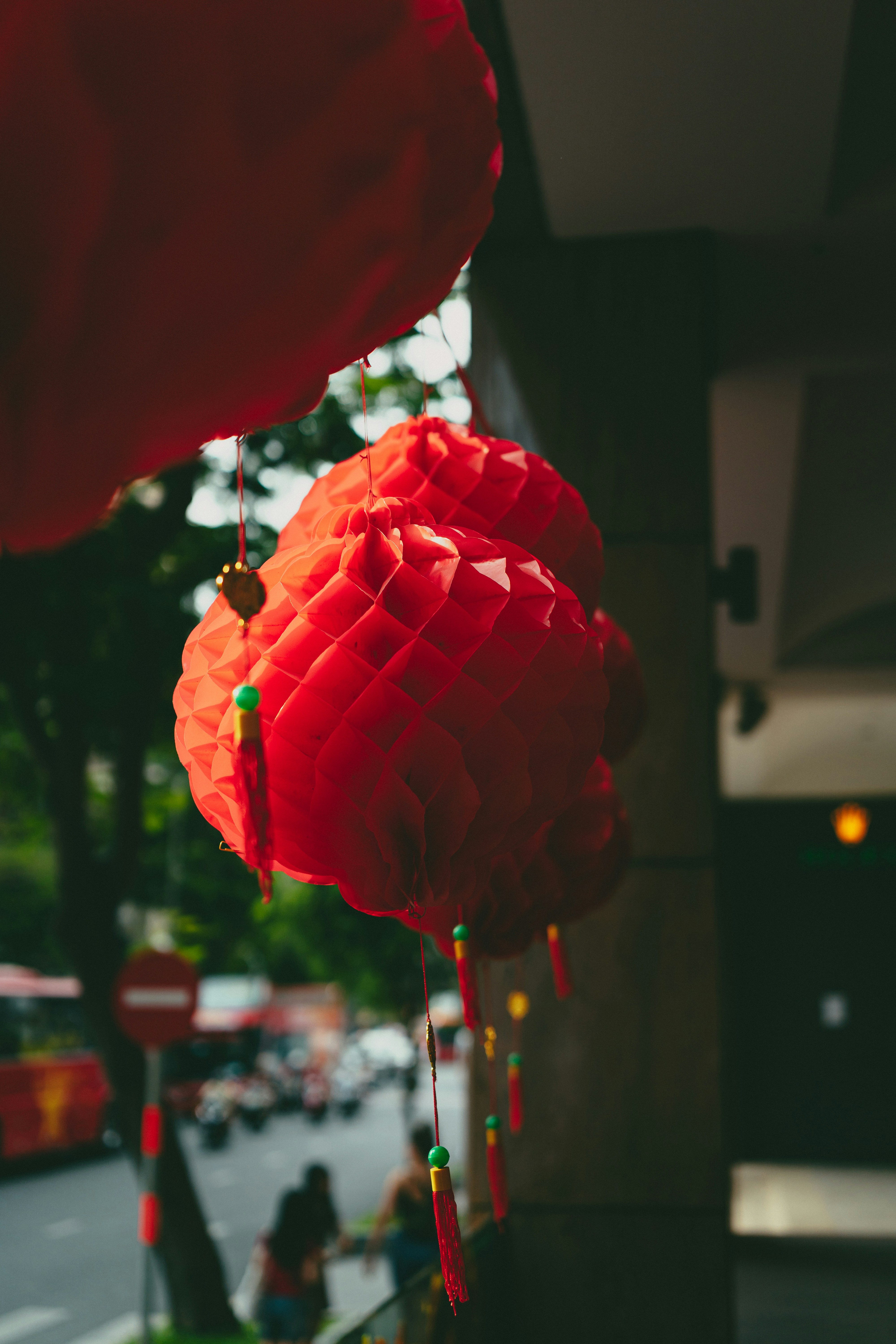A couple of red lanterns hanging from the side of a building