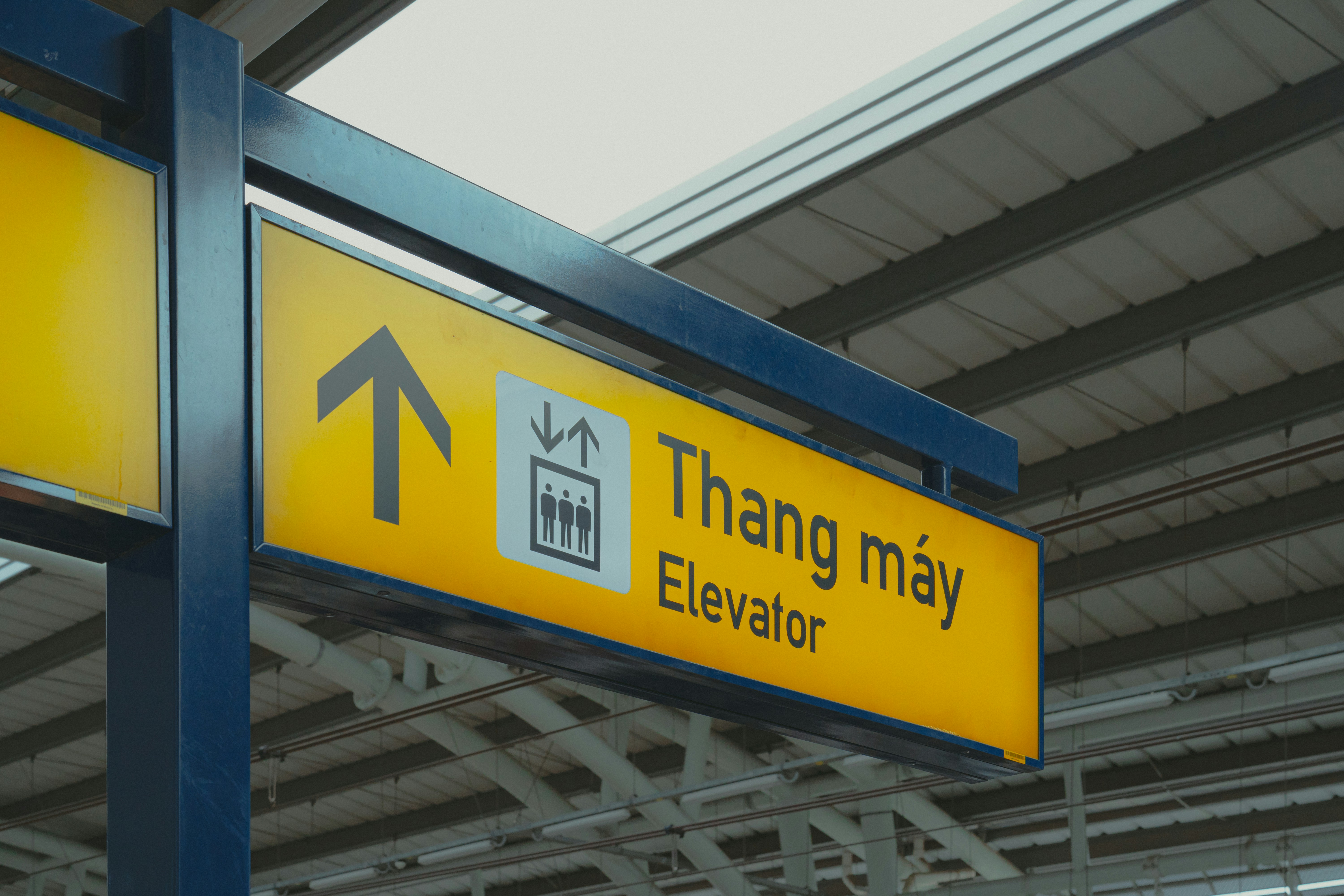 A yellow and black sign that says thang may elevator