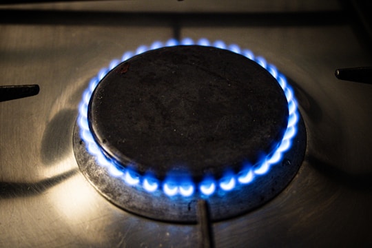 A close up of a gas stove with a blue flame