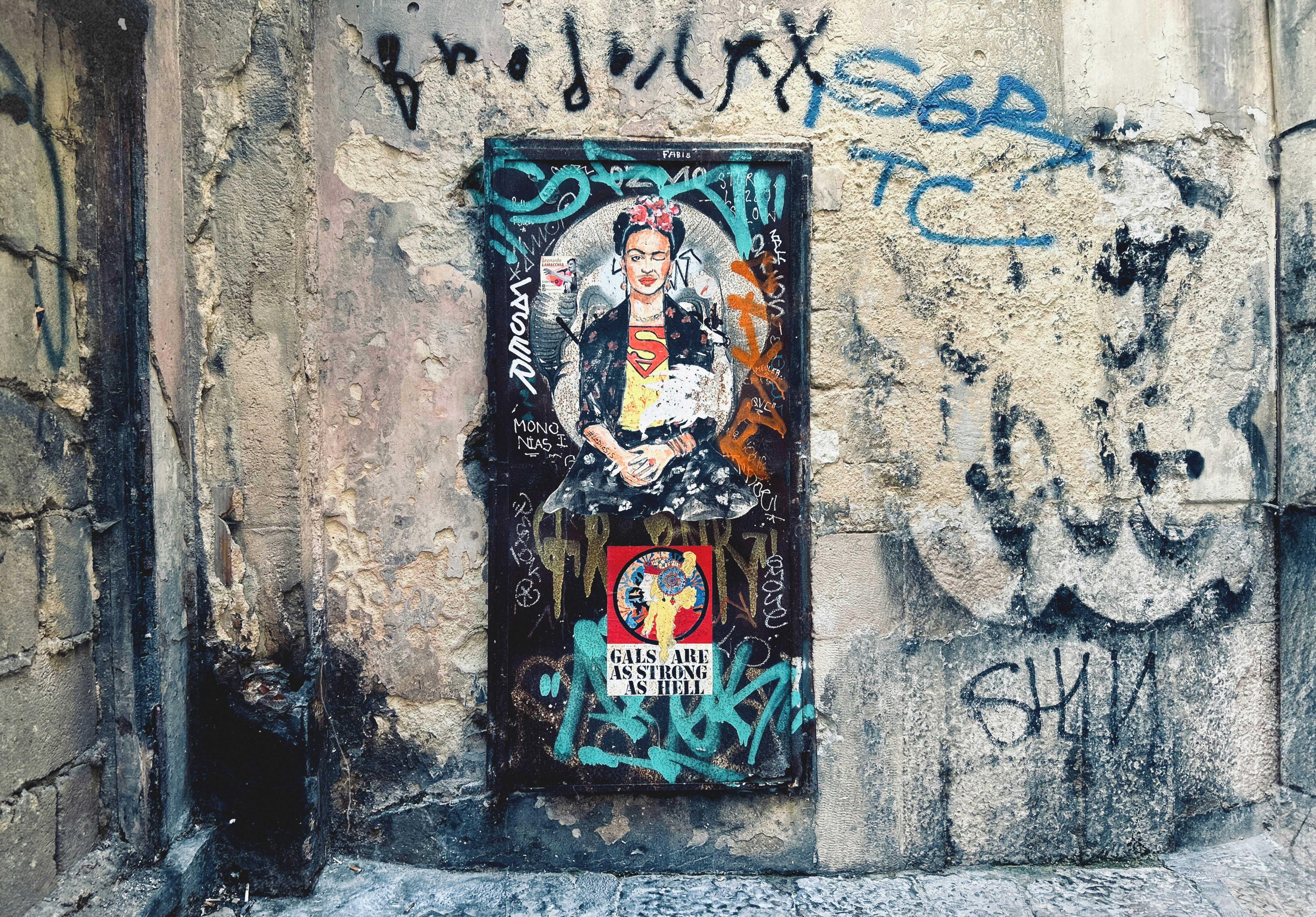 A wall with graffiti and a door with a picture on it