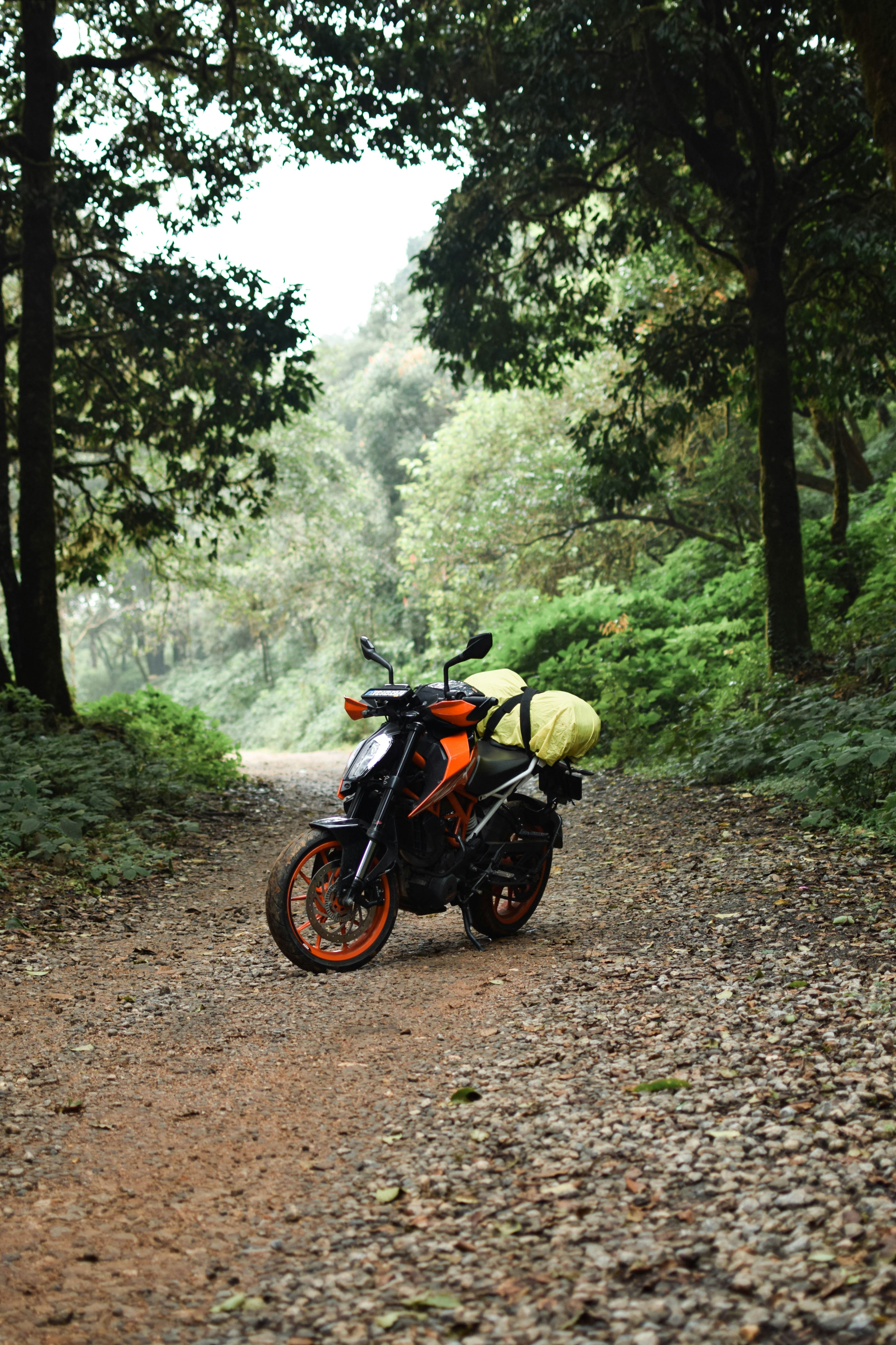 A motorcycle parked on the side of a dirt road
