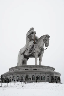 A statue of a man on a horse in the snow