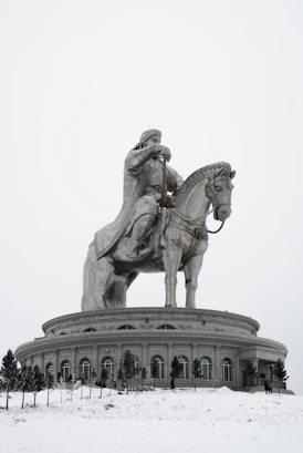A statue of a man on a horse in the snow