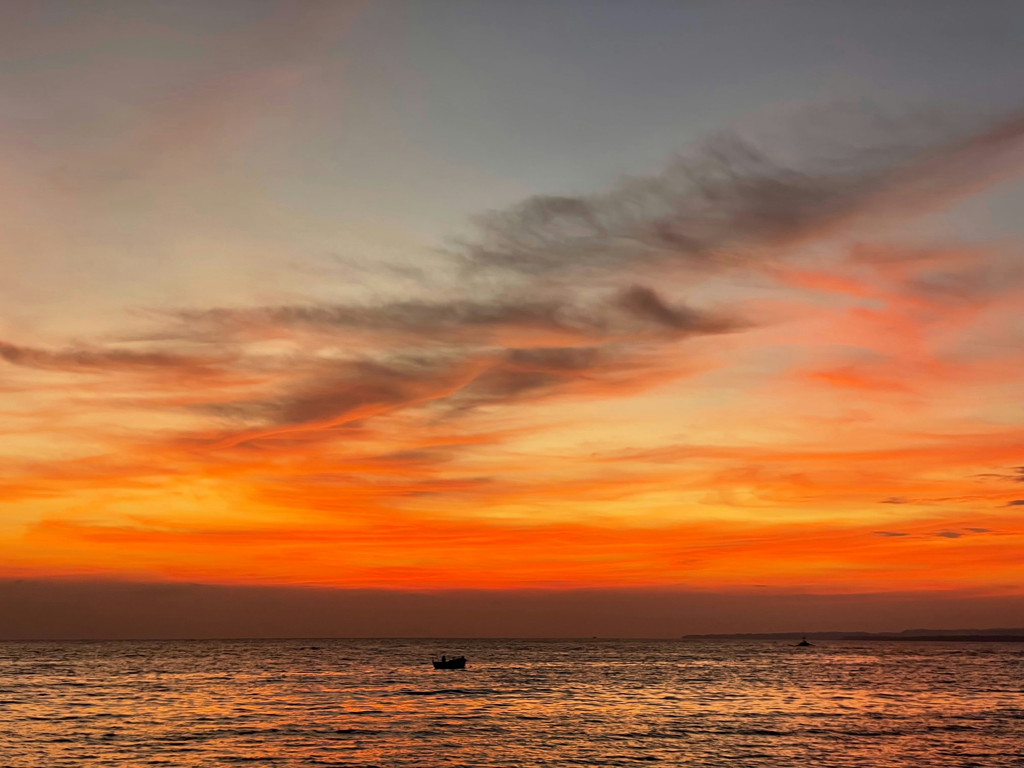 Sebuah perahu berada di atas air saat matahari terbenam